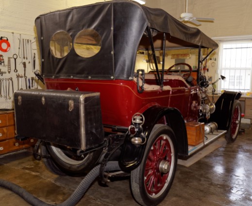 The 1914 5-passenger touring car is in Lewis's shop for repairs. You can see why we call the rear storage compartment in our modern cars a "trunk!"